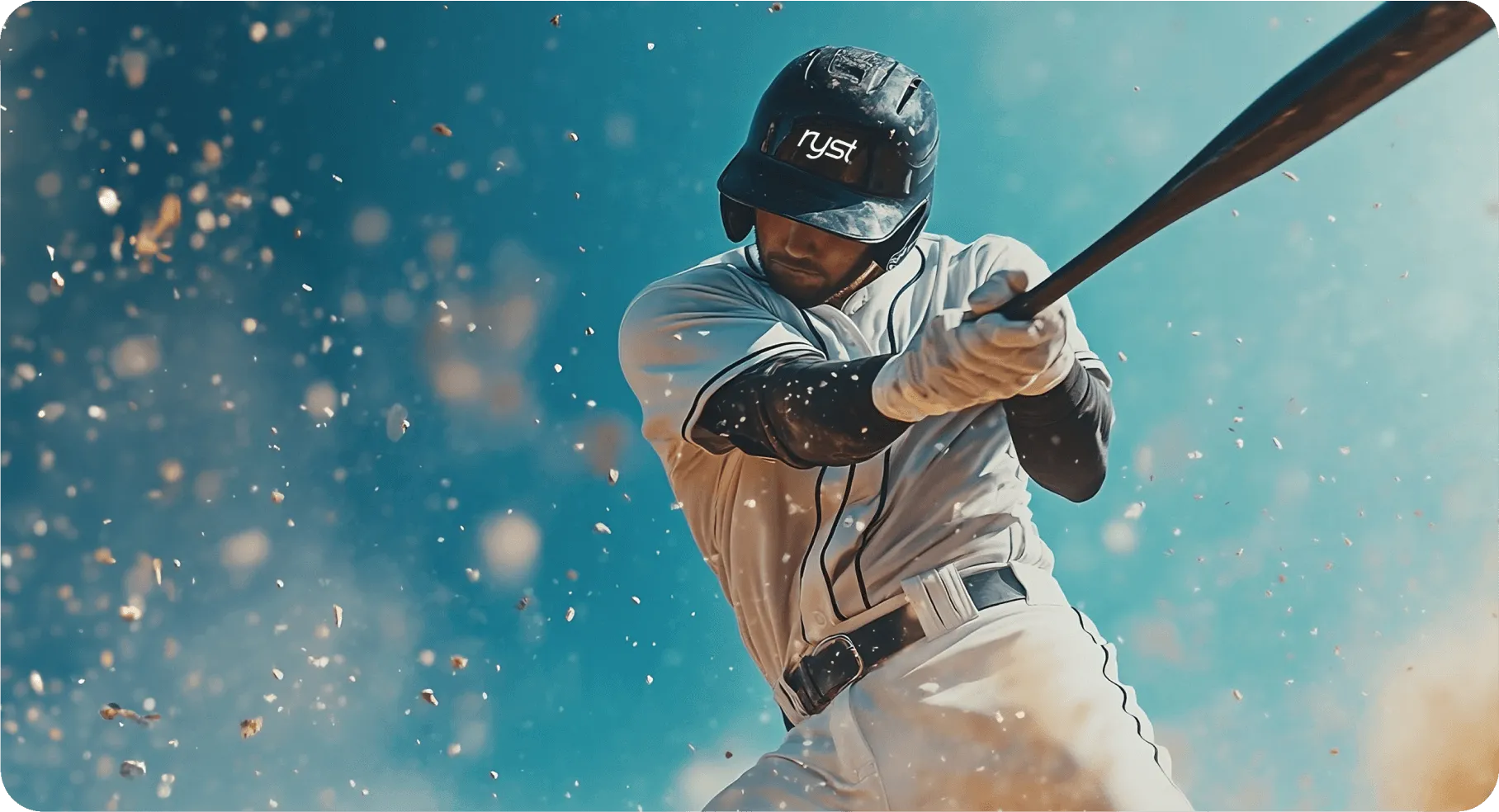 A baseball player in a white uniform swinging a bat, with bright blue sky in the background and dust and debris flying around. The 'ryst' logo is visible on his helmet
