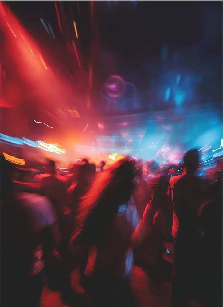 A blurred party scene with people dancing under dynamic red and blue lighting, creating an intense club atmosphere