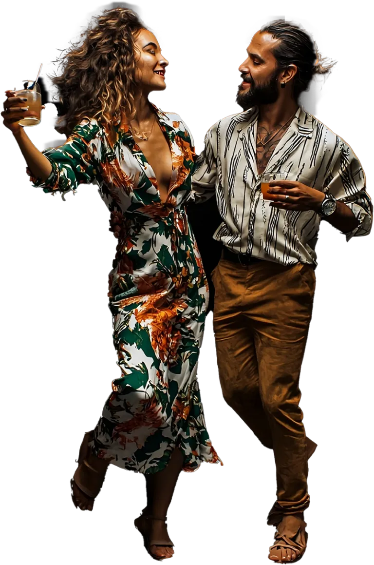 A woman in a floral dress and a man in a casual shirt and trousers dancing together, holding drinks in their hands and smiling at each other